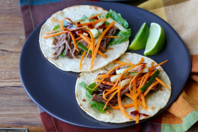 These Slow Cooker Korean-Style Beef Tacos are so so meaty and flavorful. They are filled with spicy slow cooked flank steak, as well as a fresh cucumber and carrot slaw.