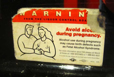 Printed warning on a mirror, saying alcohol consumption during pregancy causes fetal alchohol syndrome