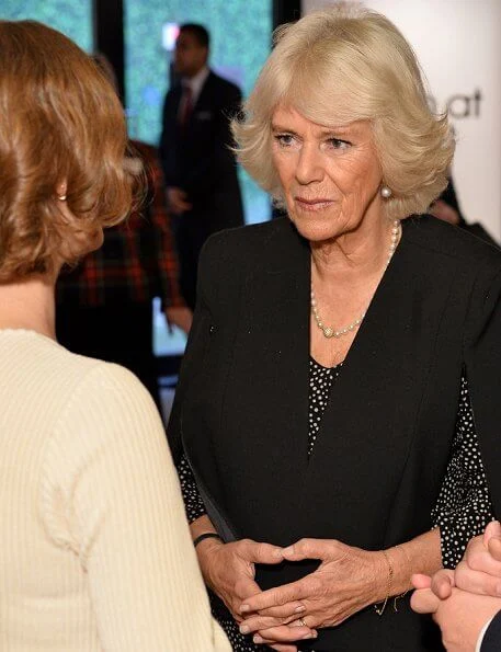 The Duchess of Cornwall sports a chic polka dot dress and ultra stylish cape at a reception for National Literacy Trust