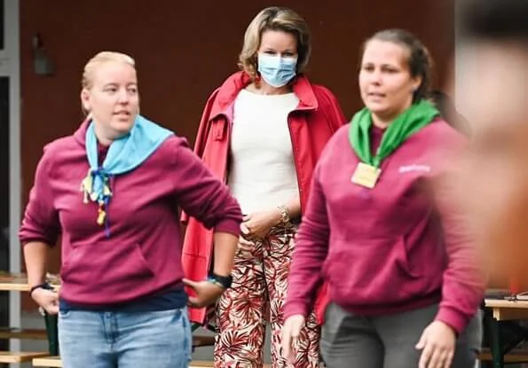 Queen Mathilde wore a top and trousers by Natan. The Queen wore a new red coat by Armani with red earrings. Princess Elisabeth