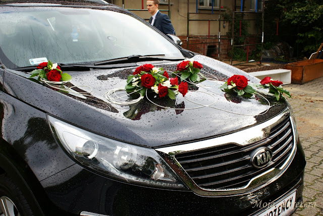 maska samochodu ślubnego z bukietami czerwonych róż i białych frezji