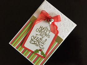 Hand made Christmas card with die cut tag shape, stamped and embossed greeting, ribbon and die cut holly