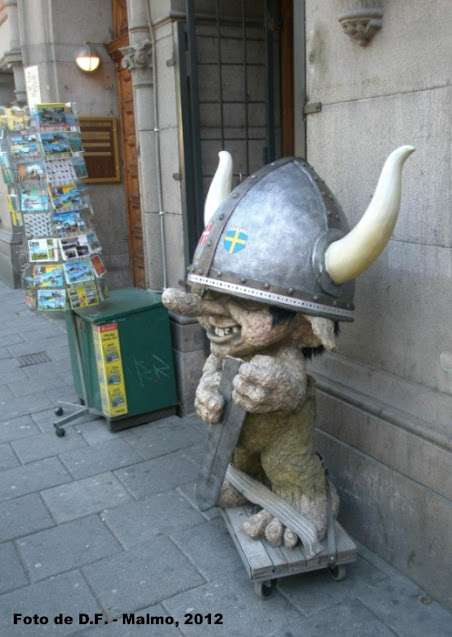 decor pe strada: spiridus din piatra cu un coif si arma de viking