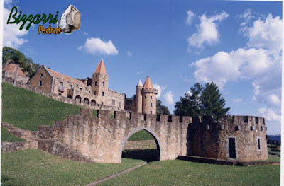 Castelo de pedra, com a torre de pedra, construído com pedra moledo nessa cor mesclada.
