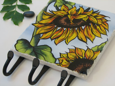 tile with sunflower painting, and three iron hooks
