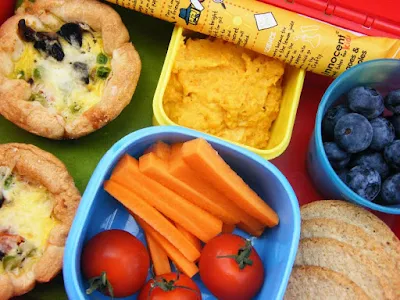 a vegetarian kids lunchbox including baby egg pies, oatcakes, carrots and cherry tomatoes