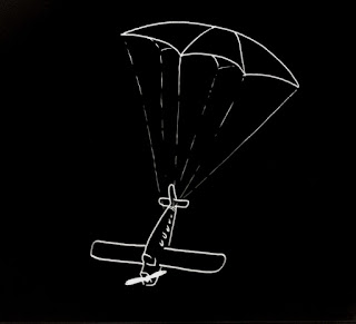 Un avión suspendido en el aire por un paracaídas