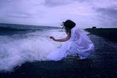 Mujer con vestido blanco en la playa