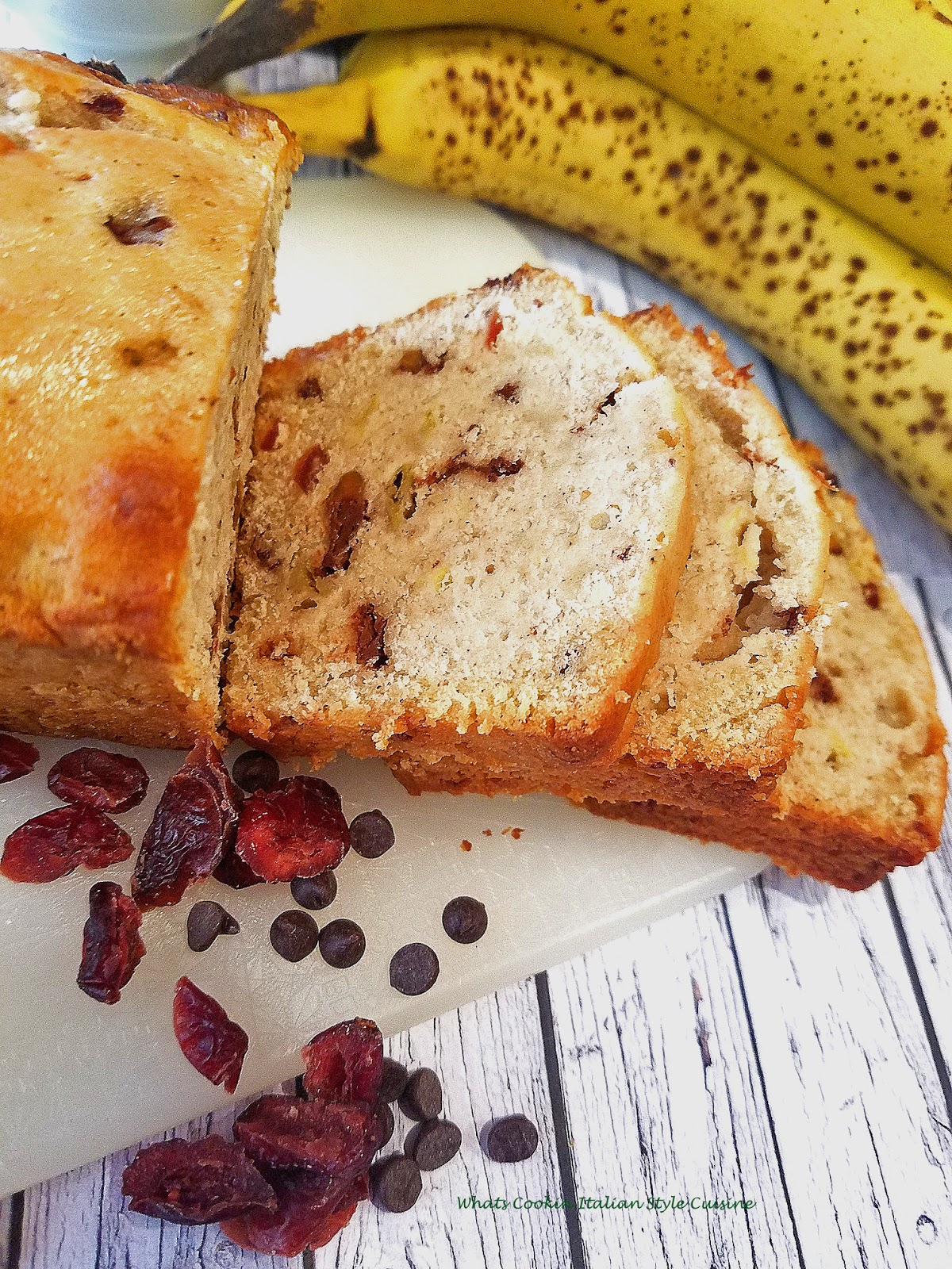 Banana bread with dried cherries and chocolate chips taste like a chocolate  covered cherry banana bread easy and simple to make banana bread on a cutting board ready to slice up and eat