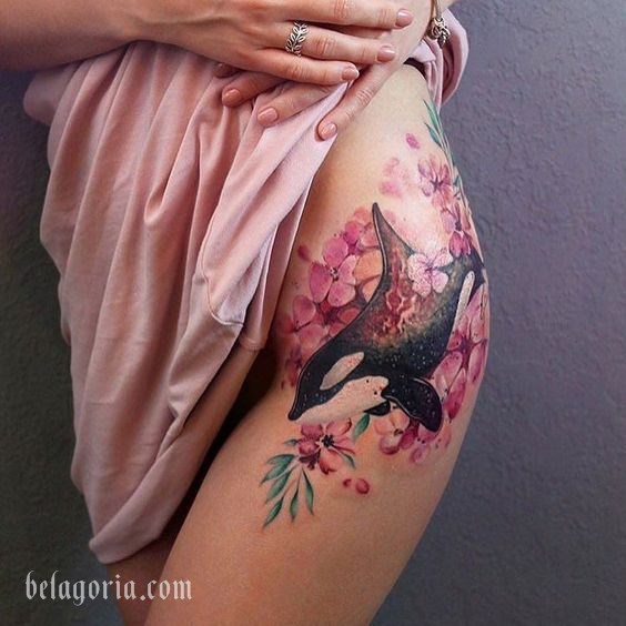 Espectacular tatuaje de orca en la cadera, las flores se asocian a la feminidad y la fragilidad.