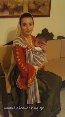 Με το νεογέννητο μωράκι της στο μάρσιπο sling και την παραδοσιακή φορεσιά, μια πανέμορφη μαμά!