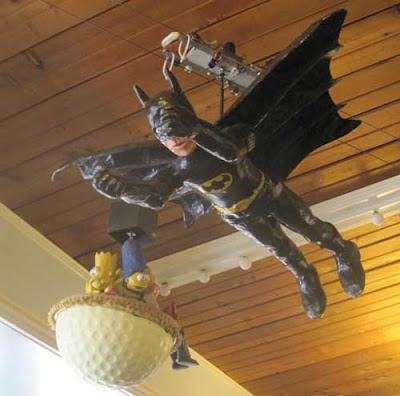 Papiere mache figure of Batman flying on wires near the ceiling