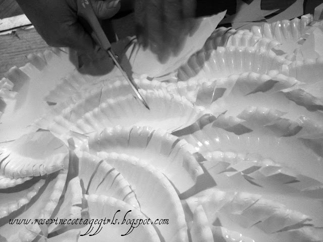 How to make angel wings, angel wings, paper wings, paper angel wings, angel wings home decor, angel wings wall hanging, by Rosevine Cottage Girls | photo of hands with scissors cutting fringe out of paper plate feathers |