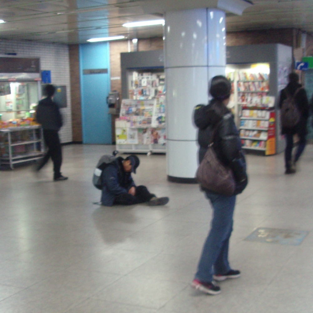 Coreano durmiendo en una estación de metro de Seúl