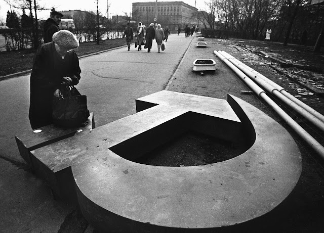 A Moscow woman rests her bag on a discarded symbol of Communism (November 1, 1990) Photograph by Alexander Nemenov