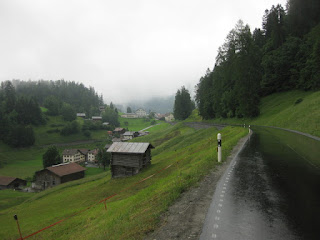 Looking back toward Versam along the rain-slicked road, Switzerland