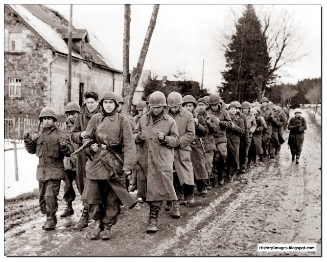 American POW walking through Belgian village December 1944