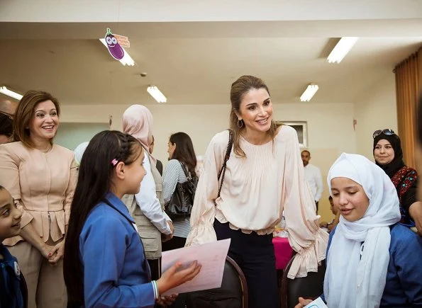 Queen Rania visited the Ballas Secondary School for Girls in Ajloun Governorate. Queen Rania style; wore Valentino blouse and Prada clutch bag