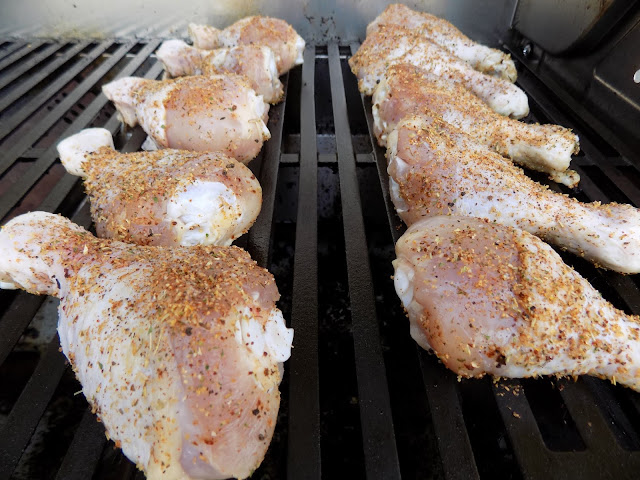 This is a picture of raw seasoned chicken legs on a grill