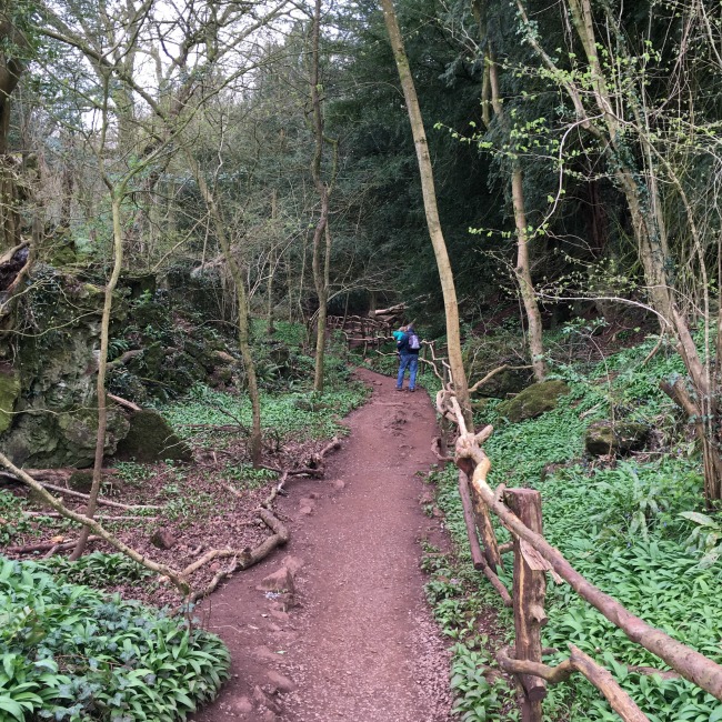 mud path with railing and man carrying toddler in distance