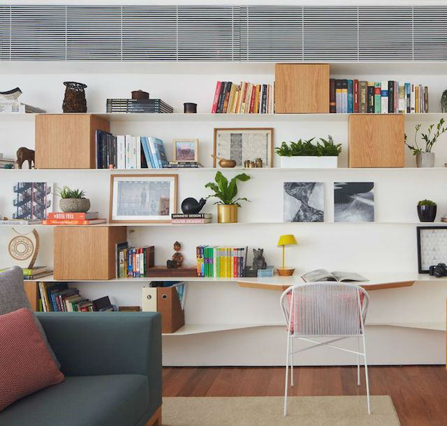 Zona de trabajo en el salón con estanterías voladas, cubos y tablas curvas