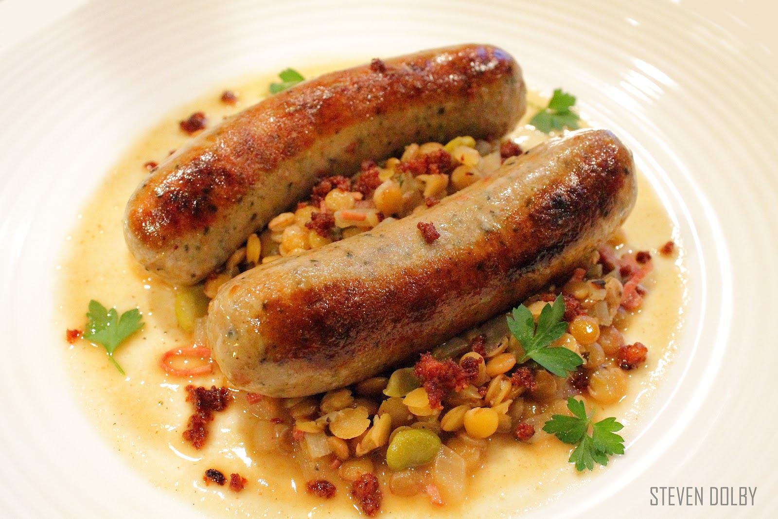 Italian sausages with braised lentils and crispy chorizo by Steven Dolby