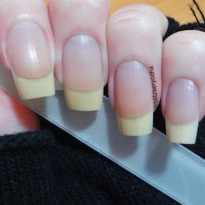 A photo of bare nails holding a nail file