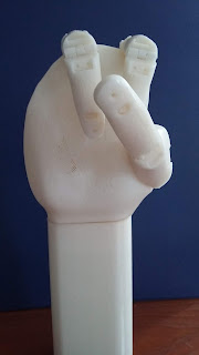 A three-fingered artificial hand, shown with fingers closed.