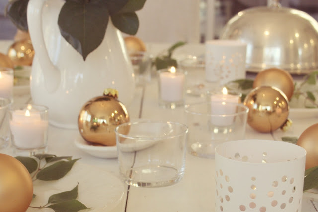 White gold and green Christmas decorated tablescape on white farmhouse table