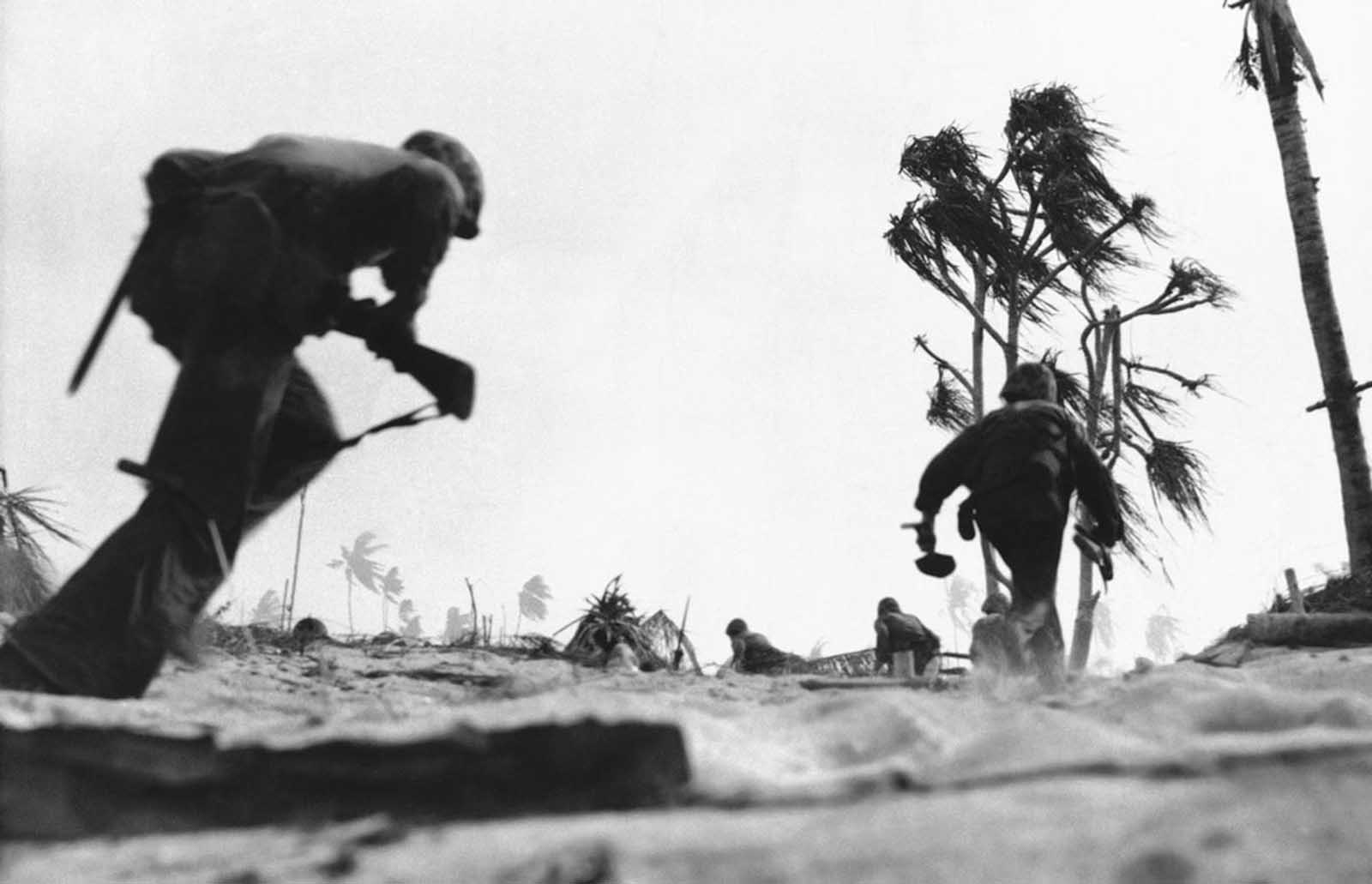 Crouching low, U.S. Marines sprint across a beach on Tarawa Island to take the Japanese airport on December 2, 1943.
