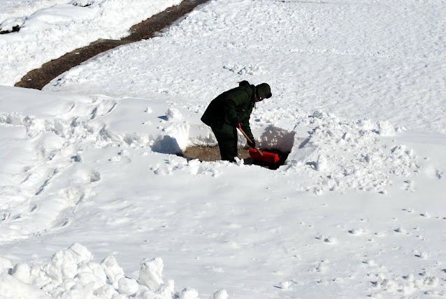 person snow shoveling in deep snow