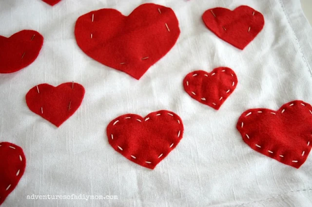 sew felt hearts to pillow with running stitch