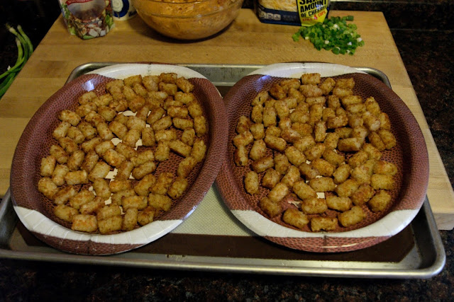 A picture of the two football plates, on a baking sheet, filled with the cooked tater tots. 