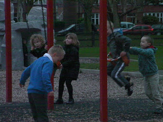 kids pushing each other on swings orange plastic nappies