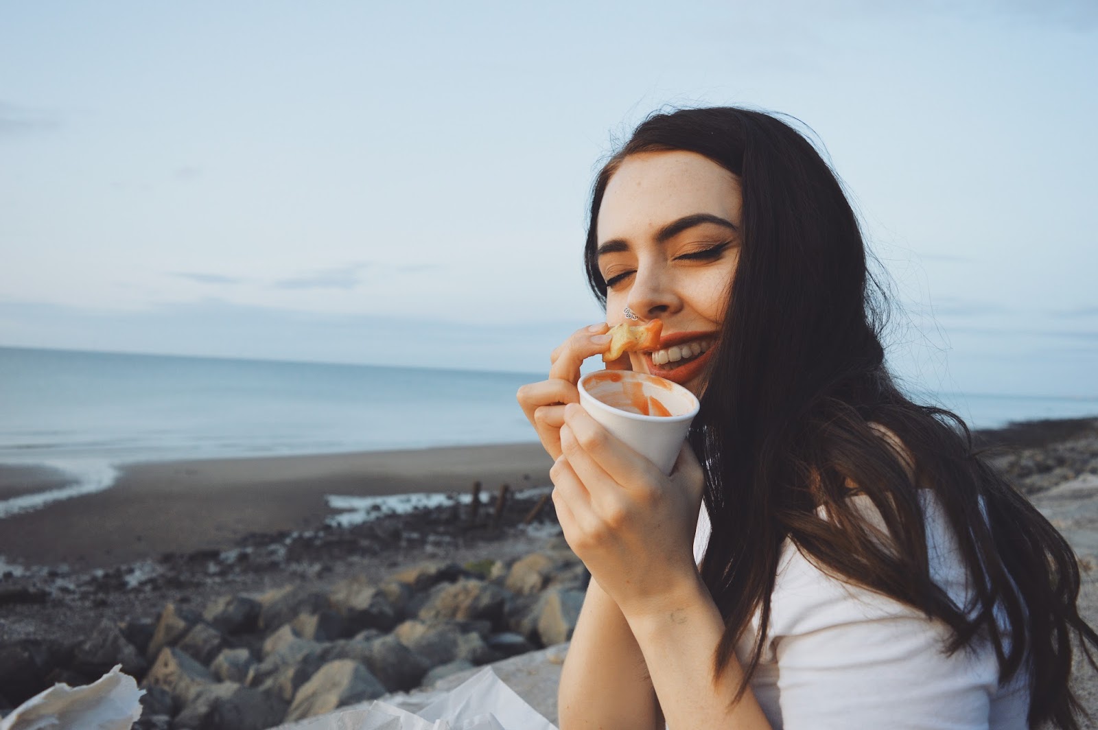 girl eating chips on seafront