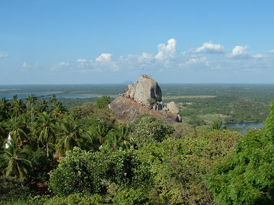Вид на Михинтале с вершиной Араханда Гала, паломники, пальмы, озера на фоне синего неба