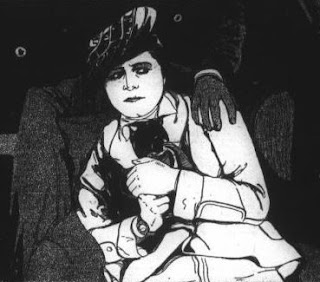 Black and white drawing of a woman in an early twentieth century suit and hat wearing dark makeup cowering in a chair, there is a gloved hand on her shoulder.