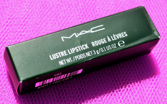 Image of the MAC lipstick box lying on bright pink fabric