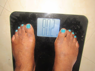 My feet Standing on a weighing scale to record my weight loss