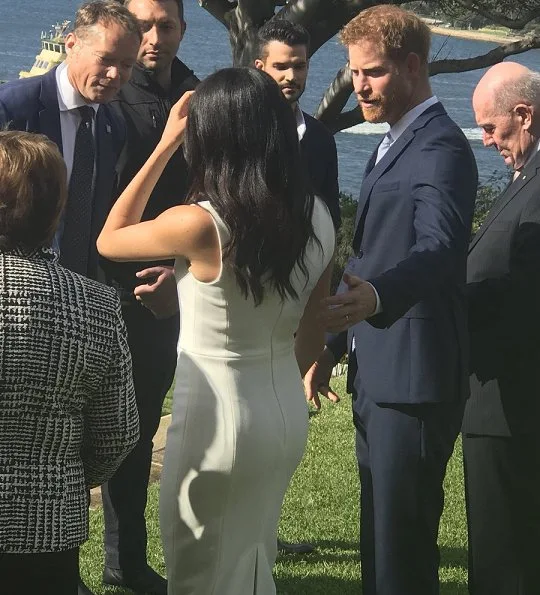 Meghan Markle wore a white Blessed dress by Australian designer Karen Gee, and she wore ​Stuart Weitzman suede pump in Haze Beige