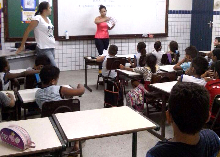 Enfermeira Hosana orientando alunos sobre o combate à dengue 