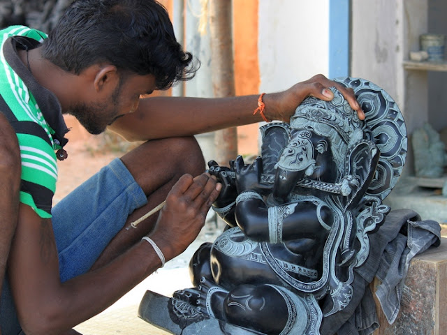 индус за работой, вырезает скульптуру из камня