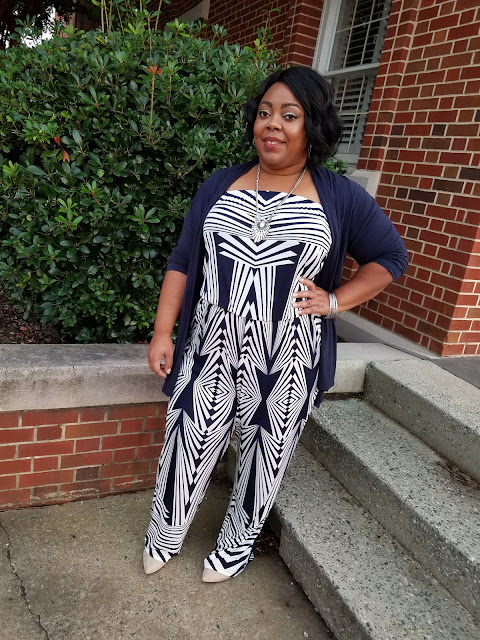 Plus size blogger in geo-print jumpsuit, nude faux suede pumps, navy open front cardigan