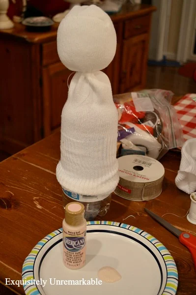 Placing a sock over a bottle to make it easier to paint