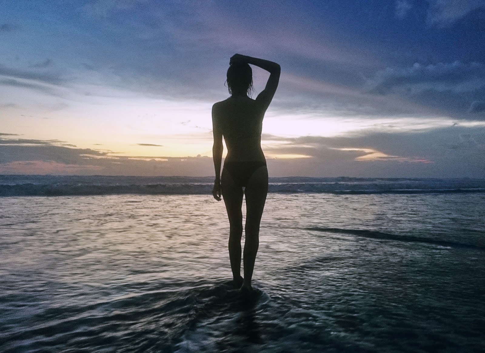 Fashion and Travel Blogger, Alison Hutchinson, swimming at sunset in Bali, Indonesia