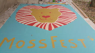 A painting of a lion's head: logo for MossFest.