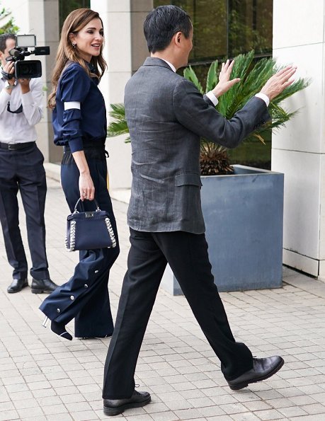 Queen Rania wore Cédric Charlier Shell trimmed Wool-blend wide leg pants, and wore Fendi Rockoko Slip On Booties and carried Fendi Peekaboo bag