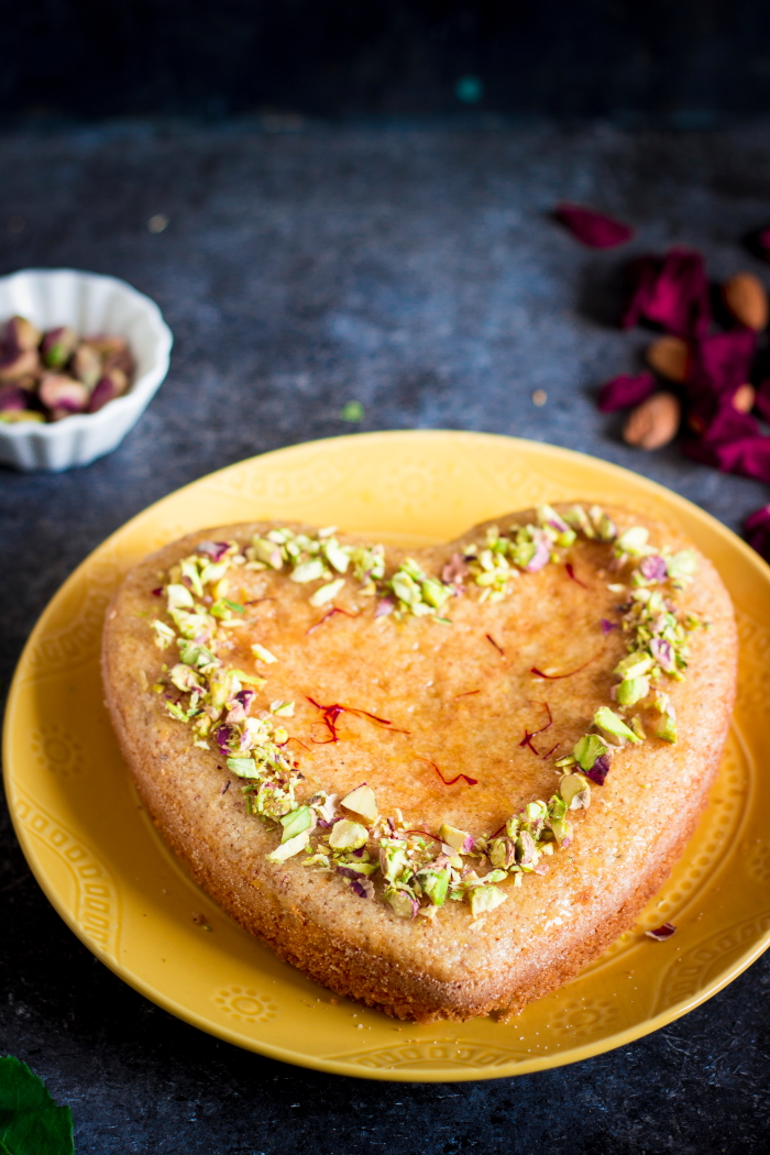Persian love cake is an eggless rose and cardamom flavored cake made with almond flour and semolina. Brushed with an orange syrup and topped with chopped nuts.