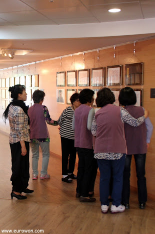 Señoras coreanas admirando los bordados budistas
