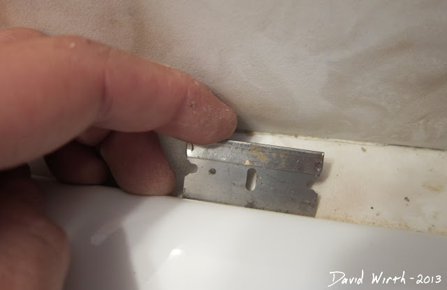 remove cracked damaged caulk with razor blade